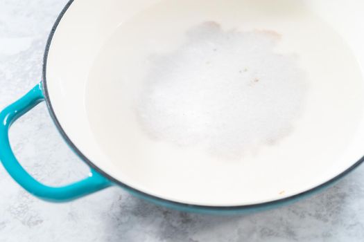 Cleaning cast iron enameled braiser with baking soda and vinegar.