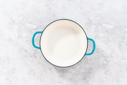 Clean cast iron enameled braiser on the kitchen counter.