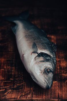 Fresh Sea Bass on Wooden Cutting Board