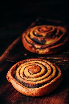 Sweet roll with poppy seeds on rustic wooden surface