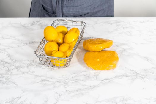 Lemon wedge cookies with lemon glaze. Wrapping cookie dough for chilling in the refrigerator to bake lemon wedge cookies with lemon glaze.