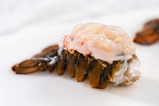 Preparing raw lobster tails to make garlic lobster tails.