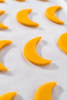 Lemon wedge cookies with lemon glaze. Rolling cookie dough with an adjustable rolling pin and cutting out cookies with cookie cutters to bake lemon wedge cookies with lemon glaze.