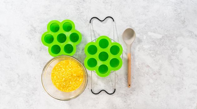 Flat lay. Filling silicone molds with egg mixture to make egg bites in a pressure cooker.