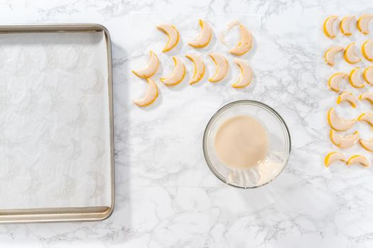 Flat lay. Lemon wedge cookies with lemon glaze. Dipping lemon cookies into a lemon glaze.