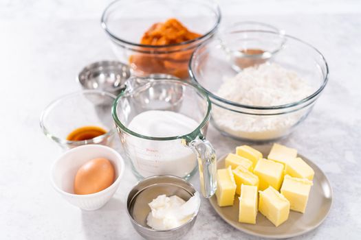 Measured ingredients in a glass mixing bowls to bake sweet pumpkin bread.