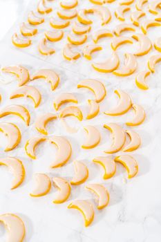 Lemon wedge cookies with lemon glaze. Dipping lemon cookies into a lemon glaze.