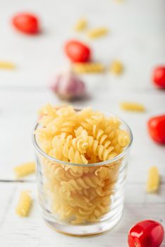 Italian fusilli pasta in glass bowl with cherry tomato and garlic