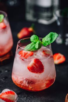 Glasses of cocktail with fresh and frozen strawberry, gin and tonic