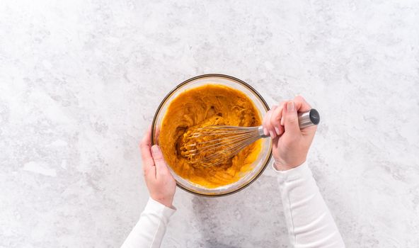 Flat lay. Mixing ingredients in a glass mixing bowl to bake sweet pumpkin bread.