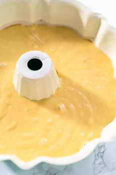 Lemon pound cake batter in a baking bundt pan ready to be baked.