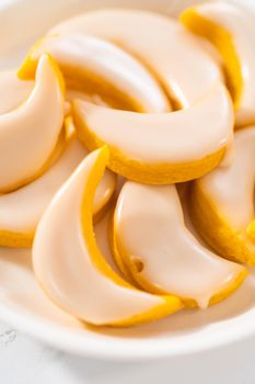 Lemon wedge cookies with lemon glaze. Freshly baked lemon wedge cookies with lemon glaze on a white plate.