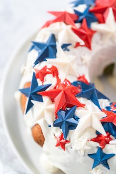 July 4th bundt cake covered with a vanilla glaze and decorated with chocolate stars on a white plate.