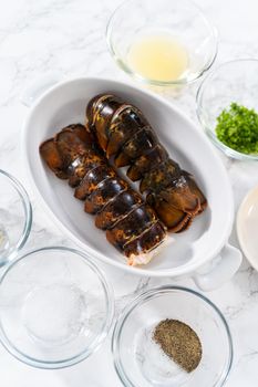 Flat lay. Measured ingredients in glass mixing bowls to prepare garlic lobster tails.