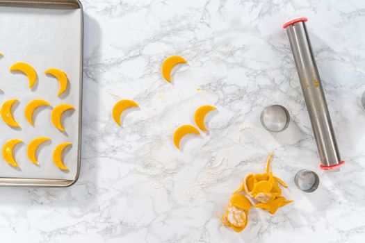 Flat lay. Lemon wedge cookies with lemon glaze. Rolling cookie dough with an adjustable rolling pin and cutting out cookies with cookie cutters to bake lemon wedge cookies with lemon glaze.