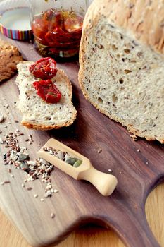 Sliced rye bread on cutting board. Whole grain rye bread with seeds. loaf of homemade whole grain bread and a cut off slice of bread. A mixture of seeds and whole grains. Healthy eating. Vertical image, selective focus