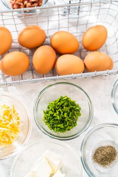 Measured ingredients in glass mixing bowls to make egg bites.