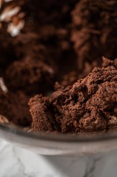 Mixing ingredients in a large glass mixing bowl to bake peppermint white chocolate cookies.