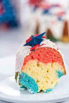 Slice of July 4th bundt cake covered with a vanilla glaze and decorated with chocolate stars.