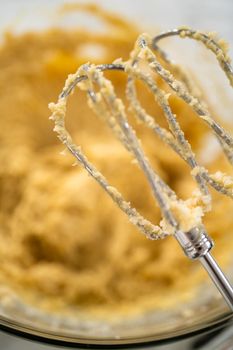 Mixing ingredients in a large glass mixing bowl to bake peppermint white chocolate cookies.