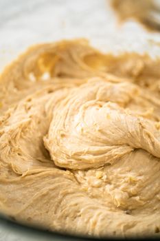 Mixing ingredients in a large glass mixing bowl to bake banana oatmeal muffins.