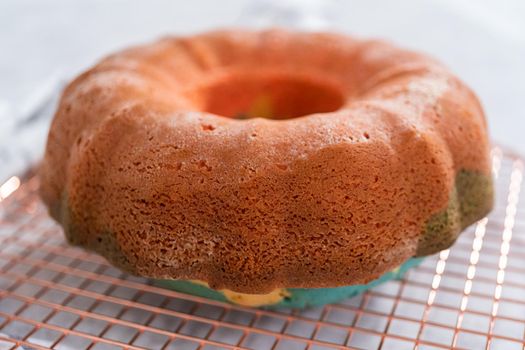 Cooling freshly baked bundt cake on a round cooling rack.