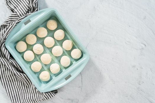 Flat lay. Baking dinner rolls from the premade frozen dough in the baking pan.