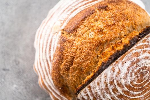 Freshly baked loaf of a wheat sourdough bread with marks from bread proofing basket.