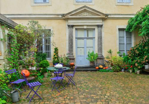 Front door decorated with autumn flowers, pumpkins and plants.