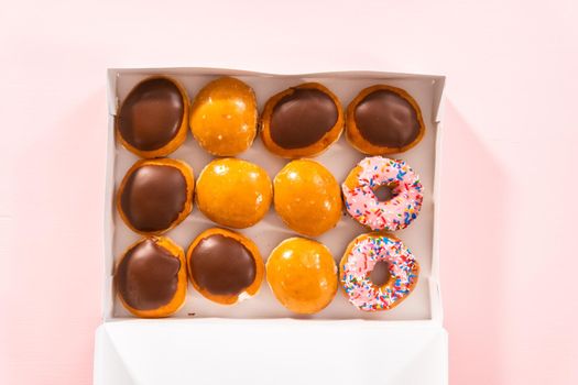 Flat lay. Variety of store-bought doughnuts in a white paper box.