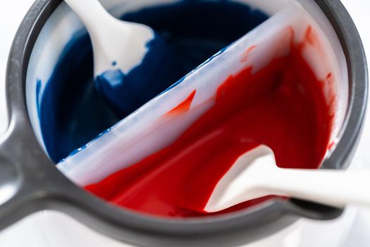 Melting chocolate chips in a candy melting pot to make red, white, and blue chocolate-covered pretzel twists.