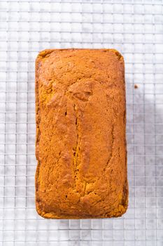 Colling freshly baked pumpkin bread on a kitchen cooling rack.