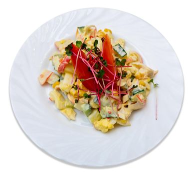 Vegetable salad with meat and red pepper on a white plate.