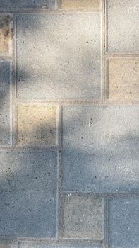 The road surface is made of natural stone in the form of square tiles. Texture natural design.