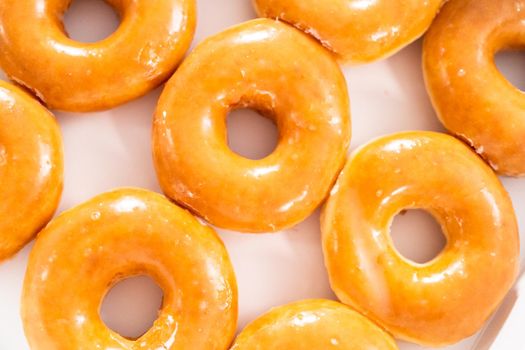 Plain glazed store-bought doughnuts in a white paper box.