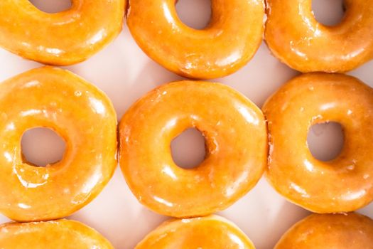 Plain glazed store-bought doughnuts in a white paper box.