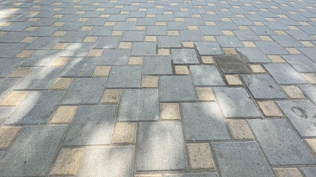 The road surface is made of natural stone in the form of square tiles. Texture natural design.