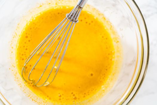 Lemon wedge cookies with lemon glaze. Mixing wet ingredients in a large glass mixing bowl to bake lemon wedge cookies.