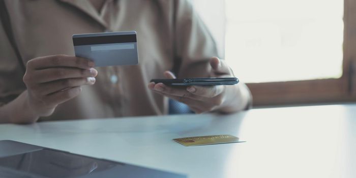 Woman hands holding smartphone shopping online with credit card. Online Payment. Online shopping concept..