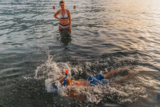 Cute happy little boy swimming and snorking in the sea. Child wearing snorkeling mask diving underwater, little boy enjoy swim underwater on tropical resort