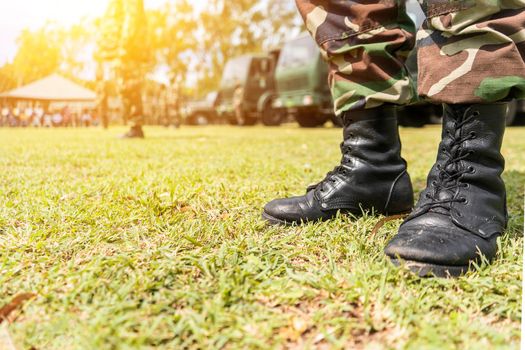 Boots of an unrecognizable Latin American soldier in a field in a military formation