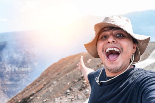 Latin man smiling taking a self portrait visiting a volcano in Masaya Nicaragua