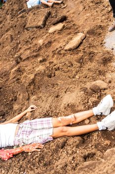 Unrecognizable young Latin woman victim of femicide lying in a pile of dirt