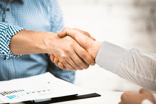 Handshake of Business partners. Close up of Male hands. Businessmen shaking hands in agreement or greeting. Toned image.