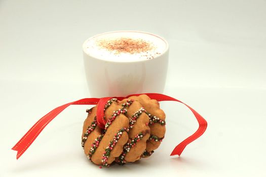 Hot drink and christmas cookies decorated with chocolate and sprinkles