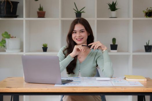 Business Woman analyzes company's financial system and paperwork on desk.