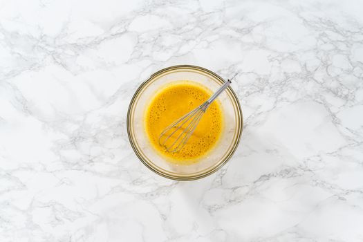 Flat lay. Lemon wedge cookies with lemon glaze. Mixing wet ingredients in a large glass mixing bowl to bake lemon wedge cookies.