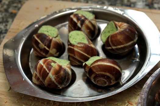 Escargots de Bourgogne on a metal plate ready to put in the oven