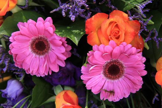 Mixed flower arrangement: various flowers in purple and orange for a wedding