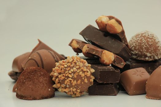 Different sorts of chocolates: bonbons and broken pieces of a chocolate bar